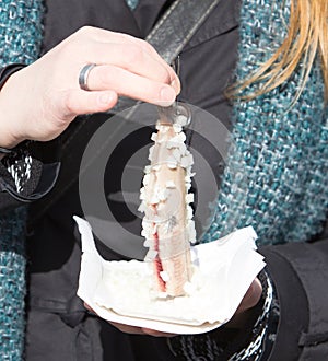 Dutch woman is eating typical raw herring