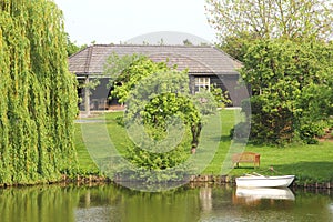 Dutch wooden home, garden and boat along canal, Netherlands