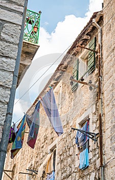 A duvet cover hanging from upper window of an old town stone building overlooking the narrow streets of Kotor ,Montenegro