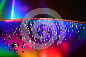 DVD and CD disc with water drops colour background.