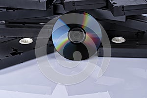 A DVD in front of videotapes and isolated on white