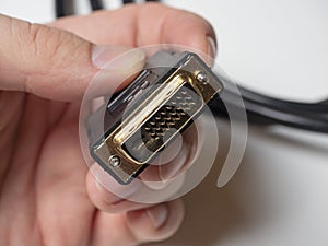 The DVI cable is black in the male hand. Cable for transmitting video images to digital display devices