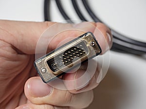 The DVI cable is black in the male hand. Cable for transmitting video images to digital display devices