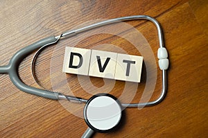 DVT the word is written on wooden cubes,plant and red pills,on white background