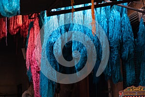 Dyed wool hanging to dry in souk in Marrakech Morocco, red, blue, yellow, gold