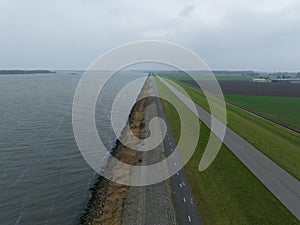 Dyke road infrastructure in The Netherlands, Holland. Flood barrier along the Ijselmeer near Lelystad and Urk. Water and
