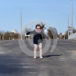 A dymanic portrait of a little girl in a city street