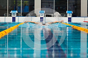 Dynamic and fit swimmer in cap breathing performing the butterfly stroke