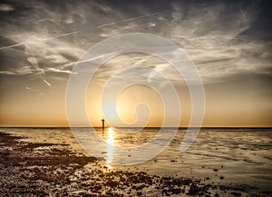 Dynamic golden sunset behind low hanging clouds over the north sea at the Dutch coast. Golden color, The Wadden Sea is a