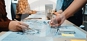 Group of Creative Professionals Collaborating on Design Projects in Modern Office Space with Sketches and Notes Spread