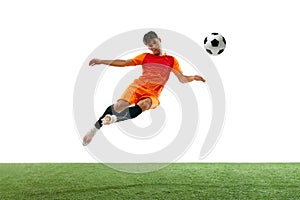 Dynamic image of competitive young man in orange uniform training, hitting ball in a jump isolated over white background