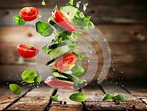 Dynamic image of fresh salad ingredients suspended in mid-air, with a rustic background