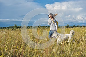 Dynamic outdoor portrait of running girl with dog