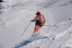 Dynamic photo of advanced skier downhill at the off piste area leaving fresh snow powder behind.