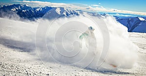 Dynamic picture of a skier on the piste in Alps. Woman skier in the soft snow. Active winter holidays, skiing downhill in sunny