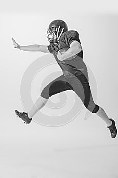 Dynamic portrait of american football player in action and motion isolated on white background. Concept of sport