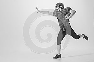 Dynamic portrait of american football player in action and motion isolated on white background. Concept of sport