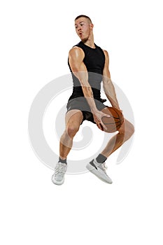 Dynamic portrait of muscled man, basketball player jumping with ball isolated on white studio background. Sport, motion