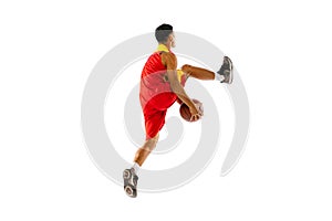 Dynamic portrait of young man, basketball player throwing ball in a jump isolated over white studio background