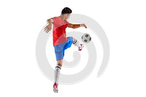 Dynamic portrait of young man, football player in motion, kicking ball isolated over white studio background. Forward