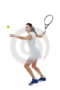 Dynamic portrait of young sportive woman, tennis player practicing isolated on white background. Healthy lifestyle