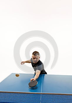 Dynamic shot of athletic, man table tennis player hitting ball in motion against white studio background.