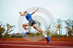 Dynamic steps leading to an impactful long jump. Bottom view full length portrait of professional sportsman running on