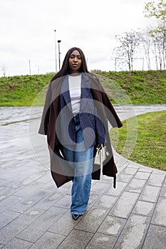 Dynamic Urban Walk: Fashion-Forward Woman in Layered Autumn Wear photo