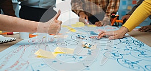 Collaborative Workshop Session with People Engaged in Brainstorming and Mind Mapping on Large Paper with Sticky Notes