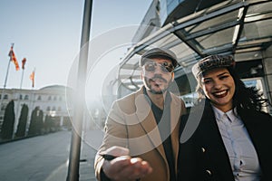 Dynamic young business people working together outdoors with urban backdrop.