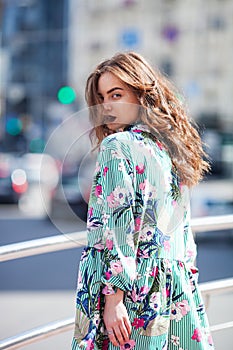 Dynamically young girl walks down the street.Hair fluttering in the wind.The concept of street fashion. Young beautiful model in