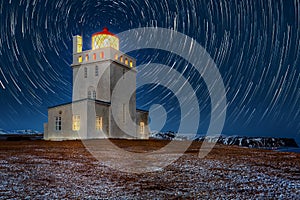 Dyrholaey lighthouse under star trails.