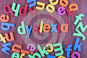 Dyslexia text with scattered alphabets on wooden table. photo