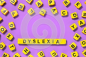 Dyslexia word yellow on pink purple with scattered letters cubes