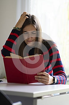 Dyslexic adult girl concept. Difficulty in reading book photo
