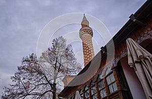 Dzhumaya Mosque and its minaret extends to cloudy sky background.