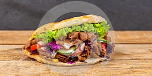 DÃÂ¶ner Kebab Doner Kebap fast food in flatbread on a wooden board panorama photo