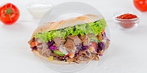 DÃÂ¶ner Kebab Doner Kebap fast food in flatbread on a wooden board panorama photo