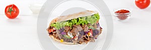 DÃÂ¶ner Kebab Doner Kebap fast food in flatbread on a wooden board panorama photo