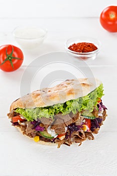 DÃÂ¶ner Kebab Doner Kebap fast food in flatbread on a wooden board portrait format photo