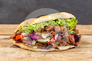 DÃÂ¶ner Kebab Doner Kebap fast food in flatbread on a wooden board photo