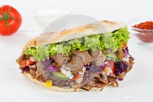 DÃÂ¶ner Kebab Doner Kebap fast food in flatbread on a wooden board photo