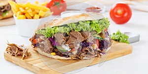 DÃÂ¶ner Kebab Doner Kebap fast food meal in flatbread with fries on a kitchen board panorama photo