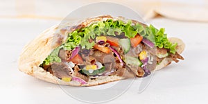 DÃÂ¶ner Kebab Doner Kebap slice fast food in flatbread on a wooden board panorama photo