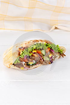 DÃÂ¶ner Kebab Doner Kebap slice fast food in flatbread on a wooden board portrait format photo