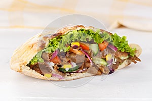 DÃÂ¶ner Kebab Doner Kebap slice fast food in flatbread on a wooden board photo