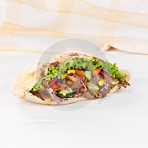 DÃÂ¶ner Kebab Doner Kebap slice fast food in flatbread on a wooden board square photo