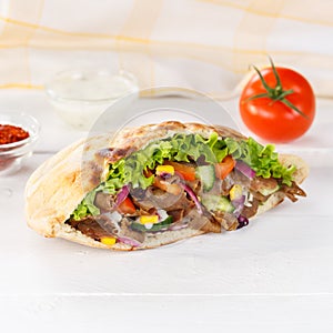 DÃ¶ner Kebab Doner Kebap fast food in flatbread on a wooden board square