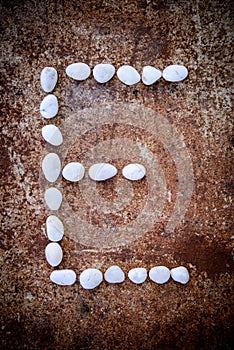 'E' alphabet made form white stone