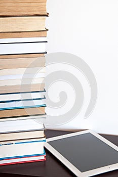 E-book reader and stack of books